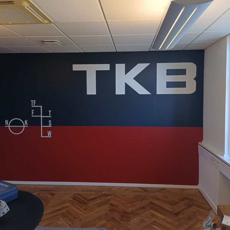 TBK Shipping malet indendørs på en rød og blå væg