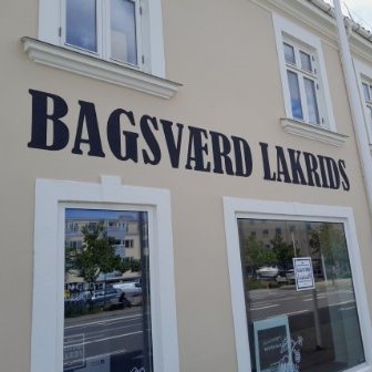 Cremefarvet facade hvor der står Bagsværd Lakrids med store bogstaver over forretnings vinduerne.